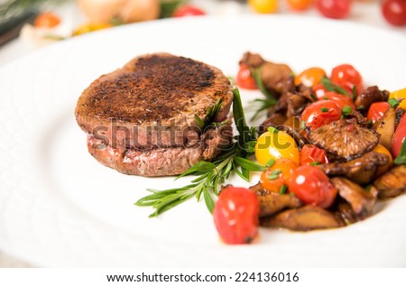 Yellow Chanterelle Mushrooms Cooked in Butter and Wine with Cherry Tomatoes Served with Medium Rare Filet Mignon