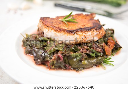 Boneless Grilled Pork Chop Served with Wilted Rainbow Chard and Collard Greens