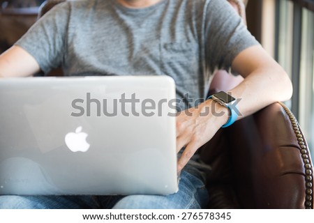 SEATTLE, USA - May 2, 2015: Man Wearing Apple Watch While Working on Computer at Local Coffee Shop