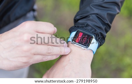 SEATTLE, USA - May 19, 2015: Man Setting Up Activity App on Apple Watch Before Biking to Work.