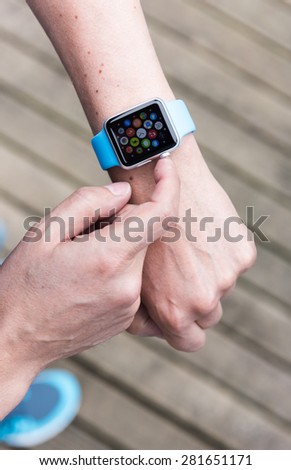 SEATTLE, USA - May 25, 2015: Man Using App on Apple Watch While Outside. Multiple Apps View.