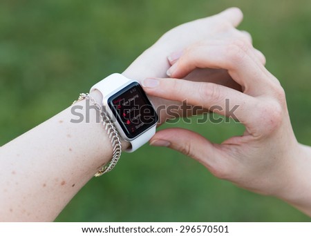 SEATTLE, USA - July 15, 2015: Woman Using Apple Watch While Outside. Using Music App to Play Songs.