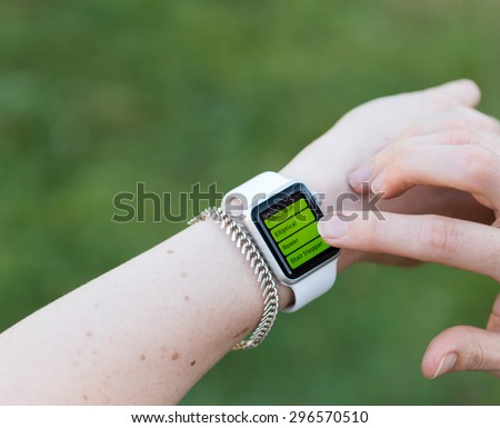 SEATTLE, USA - July 15, 2015: Woman Using Apple Watch While Outside. Using Activity App to Track Distance and Calories Per Workout.