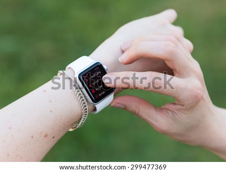 SEATTLE, USA - July 24, 2015: Woman Using Apple Watch While Outside. Using Music App to Play Songs.