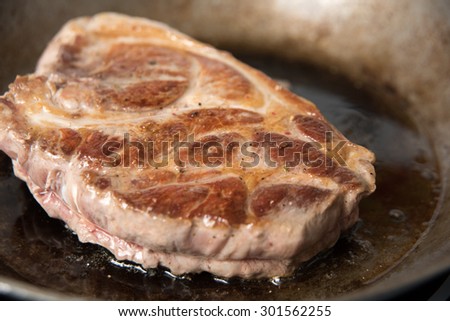 Browning Piece of Pork Shoulder on Seasoned Skillet