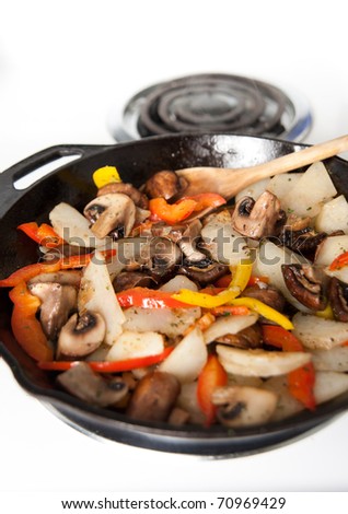 Sauteed  Mushrooms, Potatoes, and Orange Bell Peppers in Cast Iron Skillet