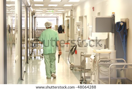 Doctor using scrubs walking at the hospital corridor