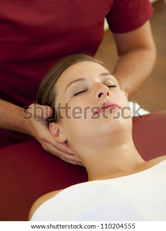head and neck massage of a beautiful woman. a woman receives a pressure point reflexology massage by her chiropractor.