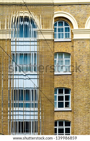 Old Building and its reflection into the glass windows of a modern urban structure
