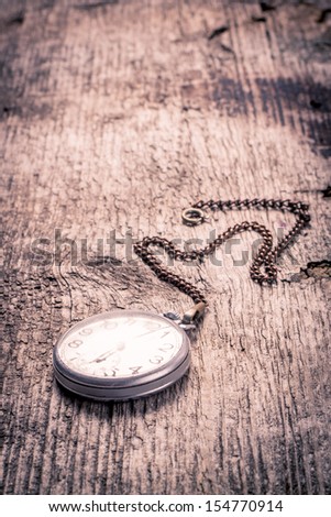 Vintage pocket watch with chain on wood background