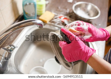Woman in rubber gloves washing up dishes and pot. Stay home clean house Stock foto © 