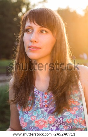 Pretty young woman glance away at summer day. Hipster caucasian girl dreaming at sunset beams