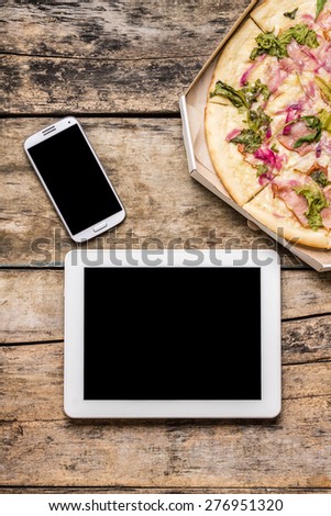 Mobile freelancer workspace with tasty pizza in box. Business lunch mock up.