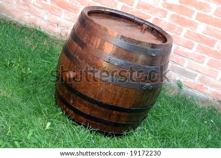 old  wooden wine brown barrel over grass and brick wall