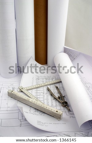 Building designs, some in a rolls of paper put together with construction measure and compasses