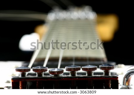 Close up at fine tuners of electric guitar with fretboard in the background