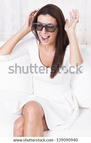 Beautiful woman watching tv in three dimensional glasses