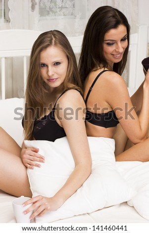 Two beautiful women on the bed