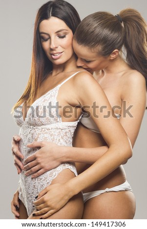 Beautiful sensual lesbian couple on gray isolated background