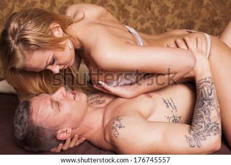 Sexy passionate young heterosexual couple embracing on the bed