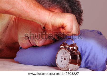 Man can not sleep and looked at the alarm clock