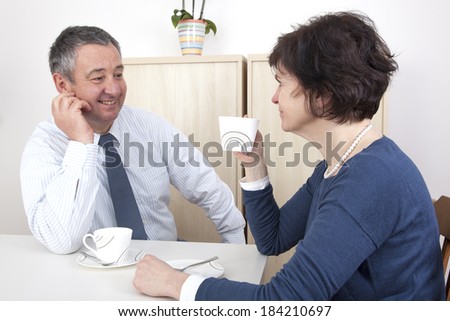 Man and woman chat over a cup of coffee