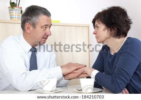 Man comforting woman over a cup coffee