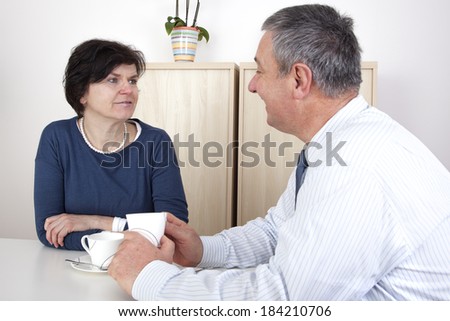 Man and woman chat over a cup of coffee