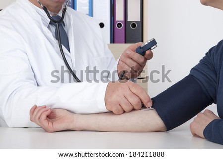 Experienced Doctor measures blood pressure