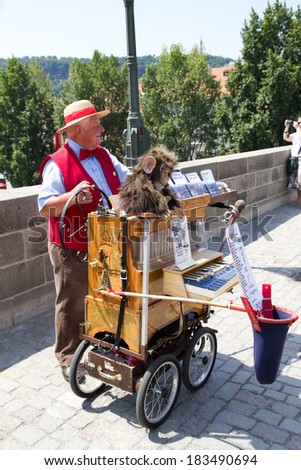 PRAGUE,CZECH REPUBLIC - JUNE 1,2010:Street musician offers music from hand operated music box in exchange for money , located in Charles Bridge  in Prague, Czech Republic.