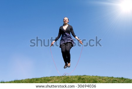 girl with skipping rope on a green meadow