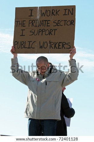 MADISON, WI - FEB 19: Unidentified man protests WI Budget Repair Bill on February 19, 2011 on the capitol square in Madison, WI.  The man holds a sign in support of public workers.