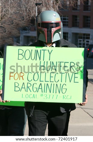 MADISON, WI - FEB 19: Unidentified man protests WI Budget Repair Bill on February 19, 2011 in Madison, WI.  The man wears a Boba Fett helmet costume and holds a sign in support of union workers.