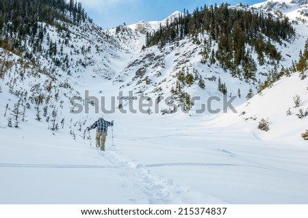 Man hiking up snow covered mountain