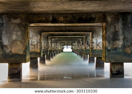 Abstract view from underneath a pier with long exposure to smooth out the waves & bring in colors