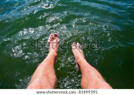 Dipping feet in water off a dock on a hot summer day