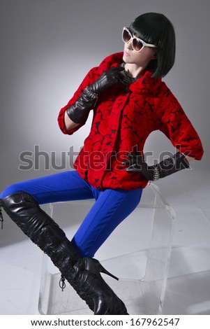 portrait of young woman in sunglasses with gloves sitting cube