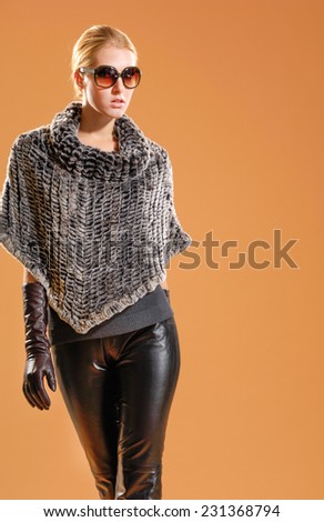 young fashion model in autumn/winter model in sunglasses posing in the studio
