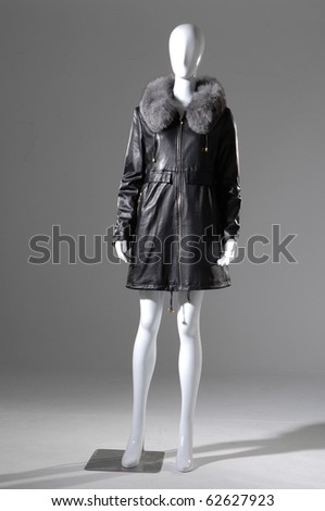 Fashion black Female fur coat on a dummy in light background