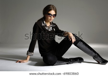 fashion model in modern clothes sitting posing in the studio