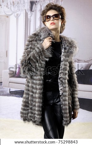 High fashion model in fur coat wearing sunglasses posing