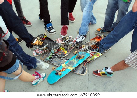 A collection of Skate boards and their owner\'s legs and feet at Limerick City Skate Park