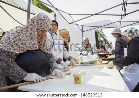 BUCHAREST, ROMANIA - MAY 17: Turkish women knead dough for traditional suberek pie during the celebratory event Turkish Festival on May 17, 2013 in Bucharest, Romania.