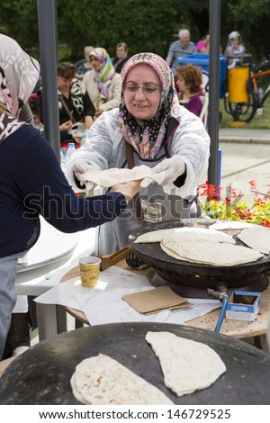 BUCHAREST, ROMANIA - MAY 17: Turkish women bake traditional suberek pie during the celebratory event Turkish Festival on May 17, 2013 in Bucharest, Romania.