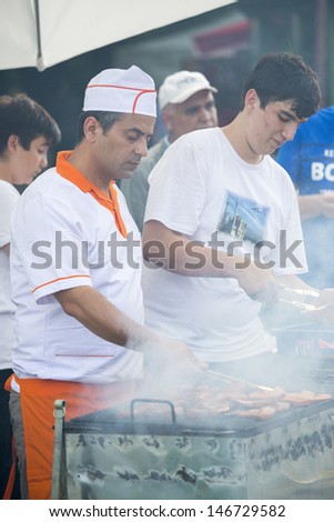 BUCHAREST, ROMANIA - MAY 17: Turkish men cooks prepare traditional meat grill during the celebratory event Turkish Festival on May 17, 2013 in Bucharest, Romania.