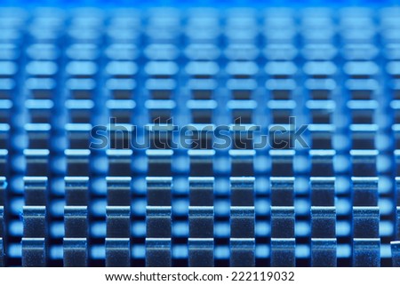 Abstract macro background with blue repetitive metal teeth pattern with shallow depth of field.