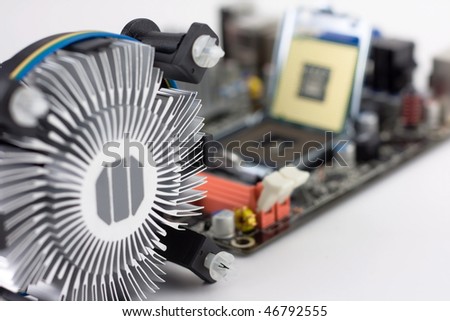 CPU fan with aluminum radiator and motherboard out of focus