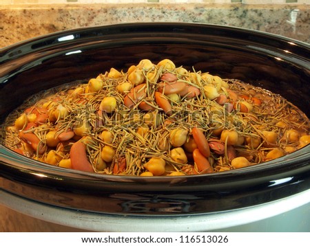 a combination of kidney beans, chick peas, and black eyed peas simmering in a crock pot
