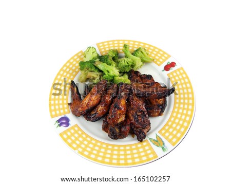 meal of chicken wings and broccoli on a plate isolated on a white background