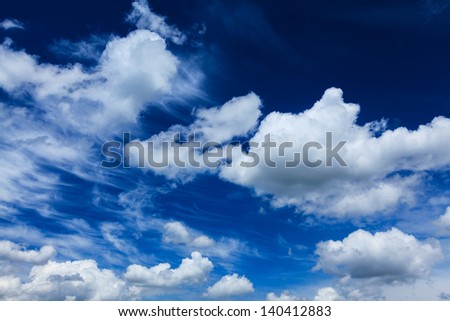 Cloudscape with wind shaped clouds profiled on deep blue sky